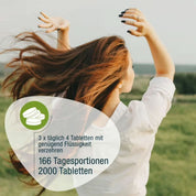 Eine Frau mit langen braunen Haaren steht mit erhobenen Armen auf einer grünen Wiese. Naturland Bio Spirulina (gse.organic.supplements): 3x täglich 4 vegane Tabletten mit reichlich Flüssigkeit einnehmen; Packung enthält 2000 Tabletten für 166 Tagesportionen.